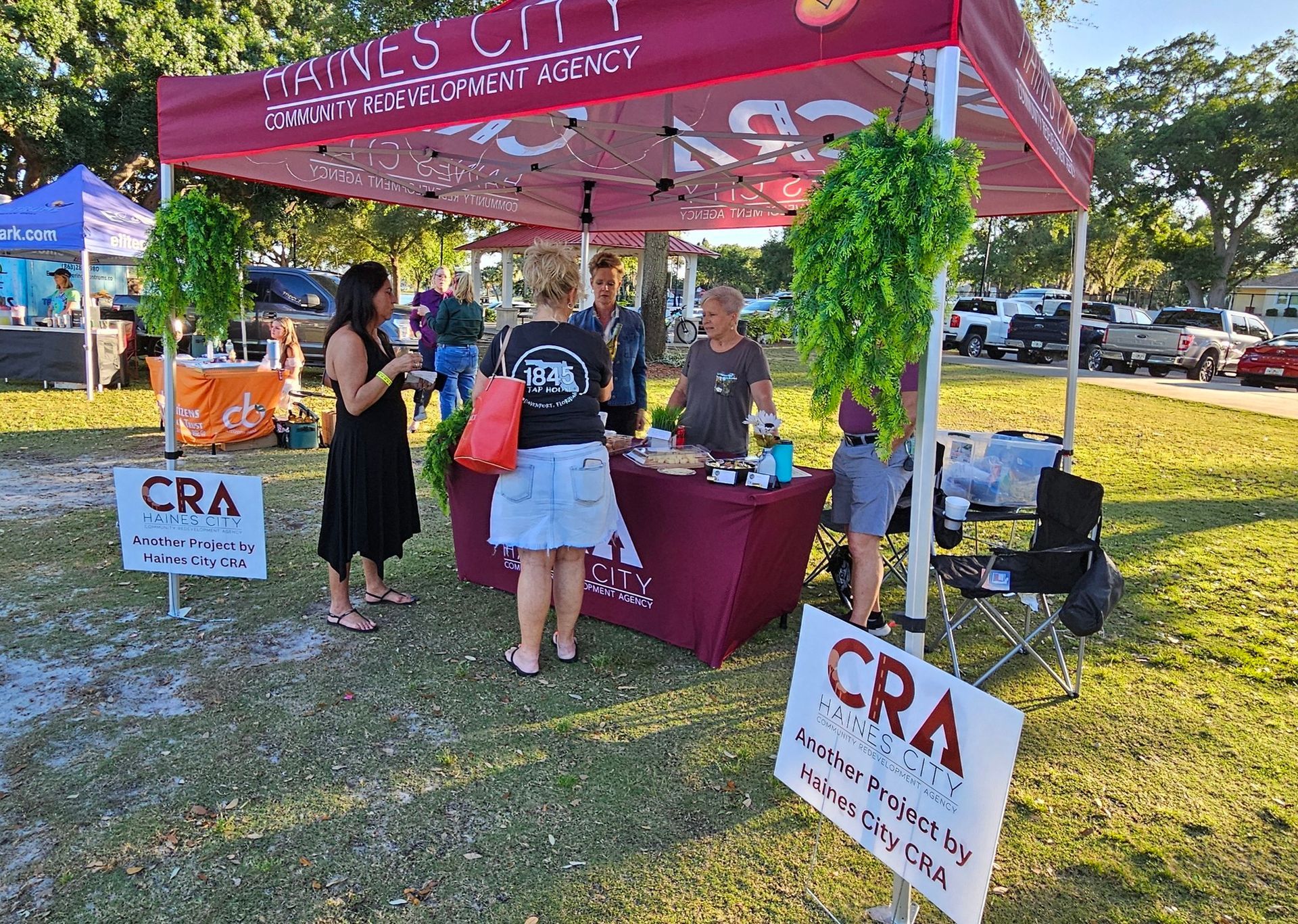 A group of people are standing around a table under a tent.