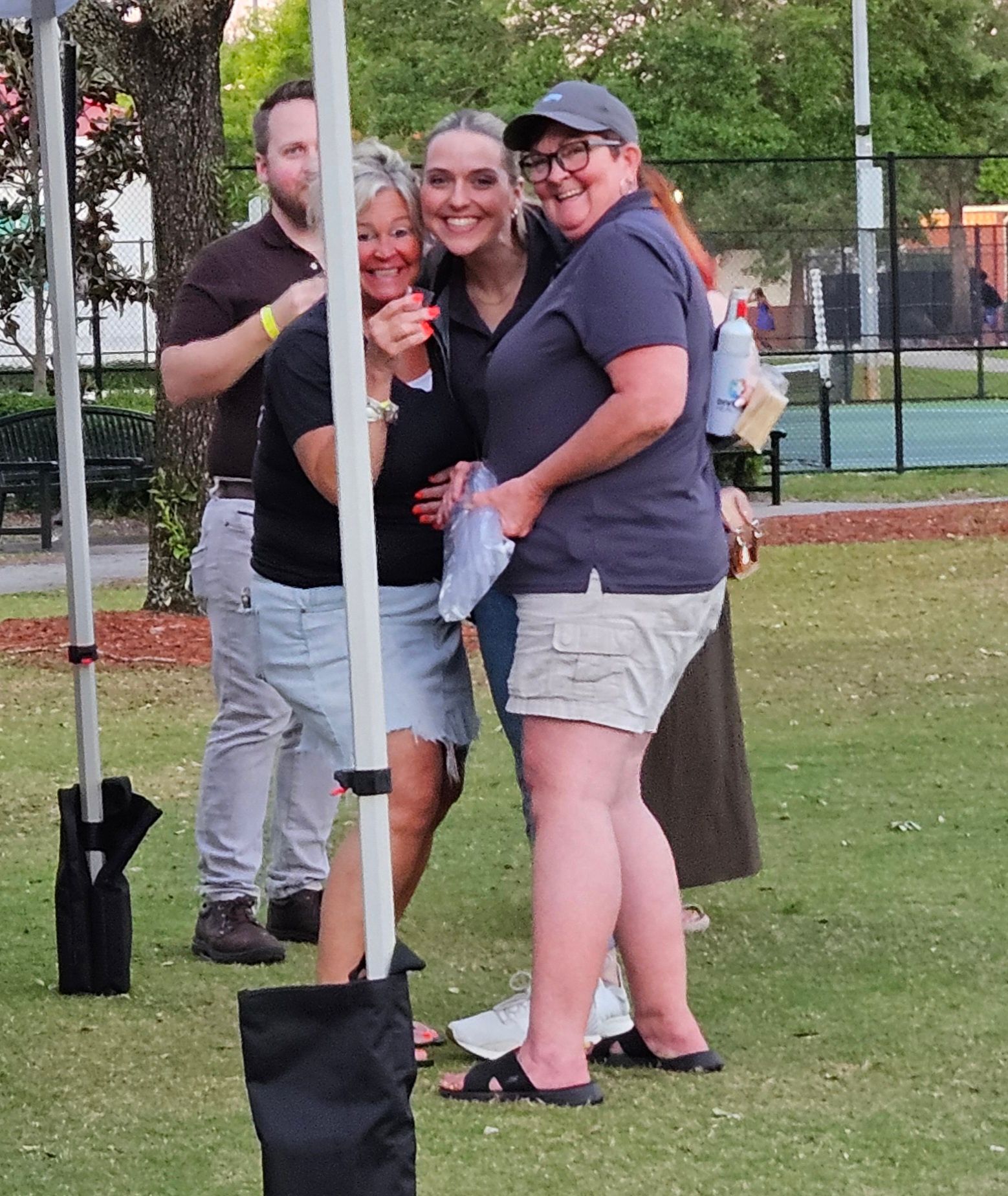 A group of people standing under a tent in a park