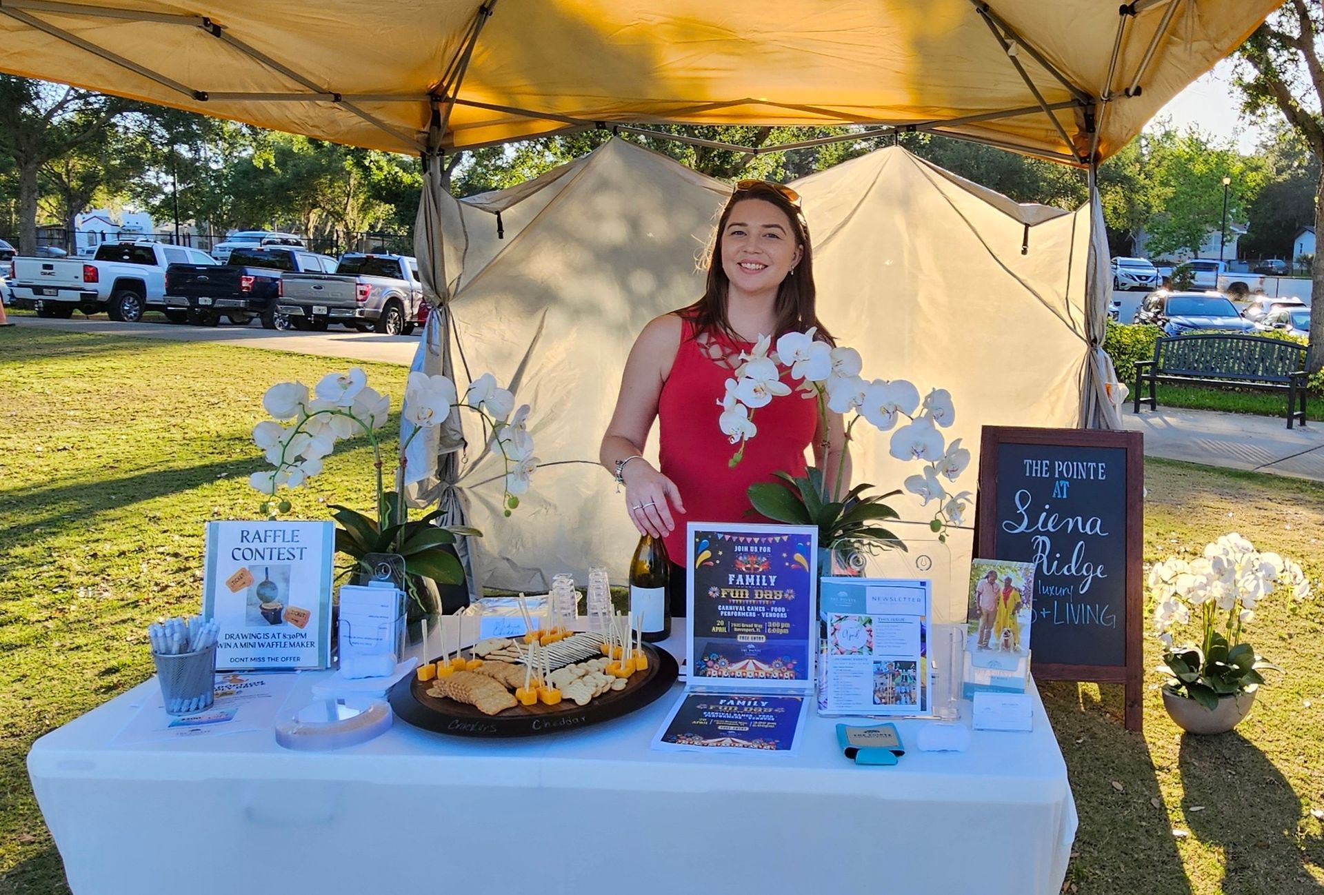 A woman is standing at a table under a tent.