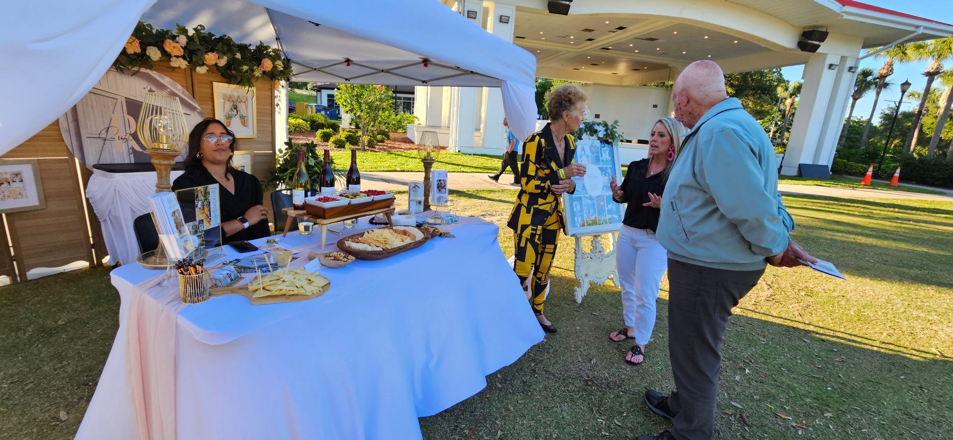 A group of people are standing around a table under a tent.