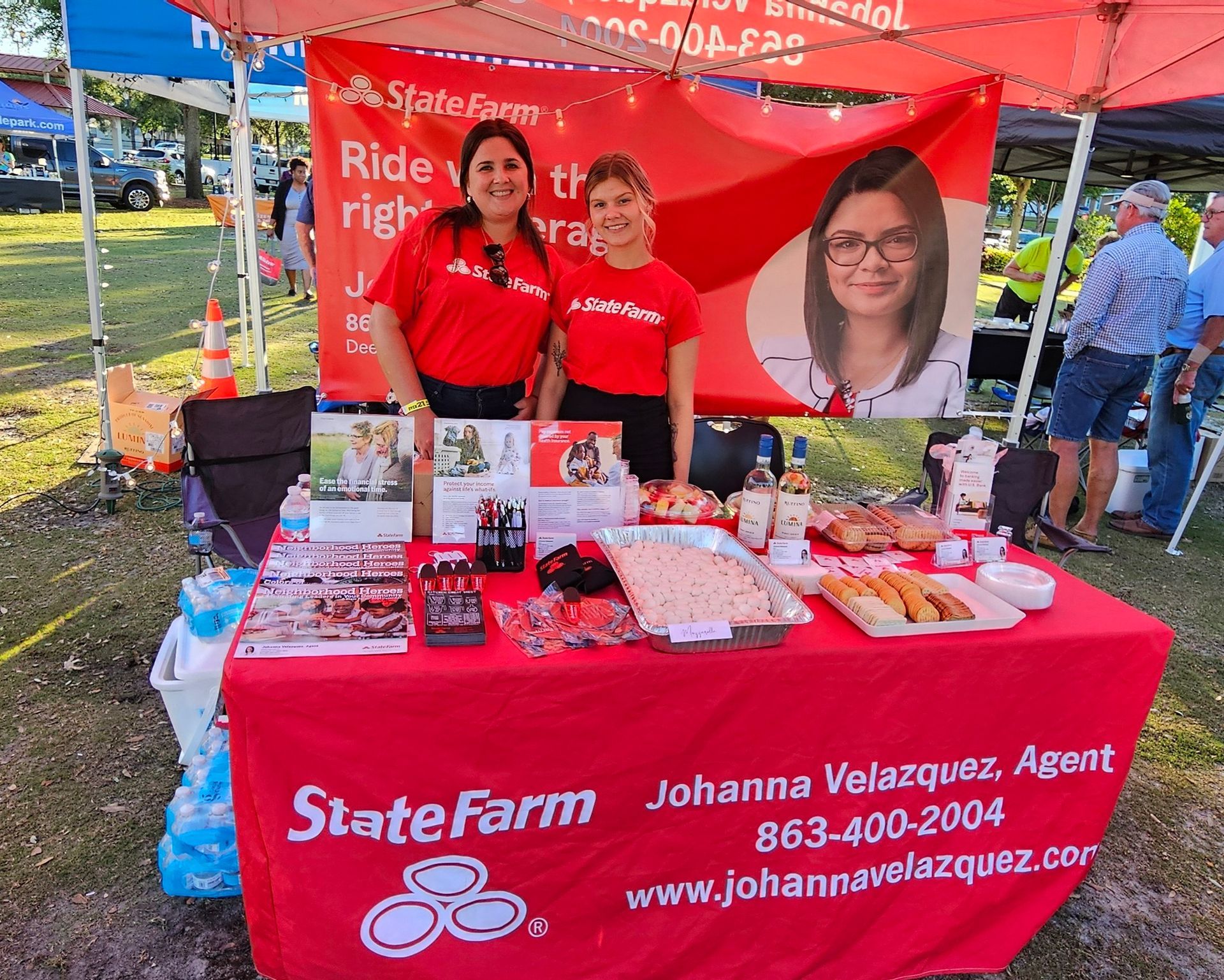 Two women standing in front of a state farm table