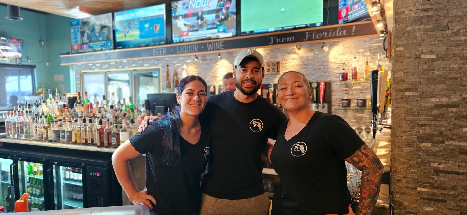 A group of people are posing for a picture in front of a bar.