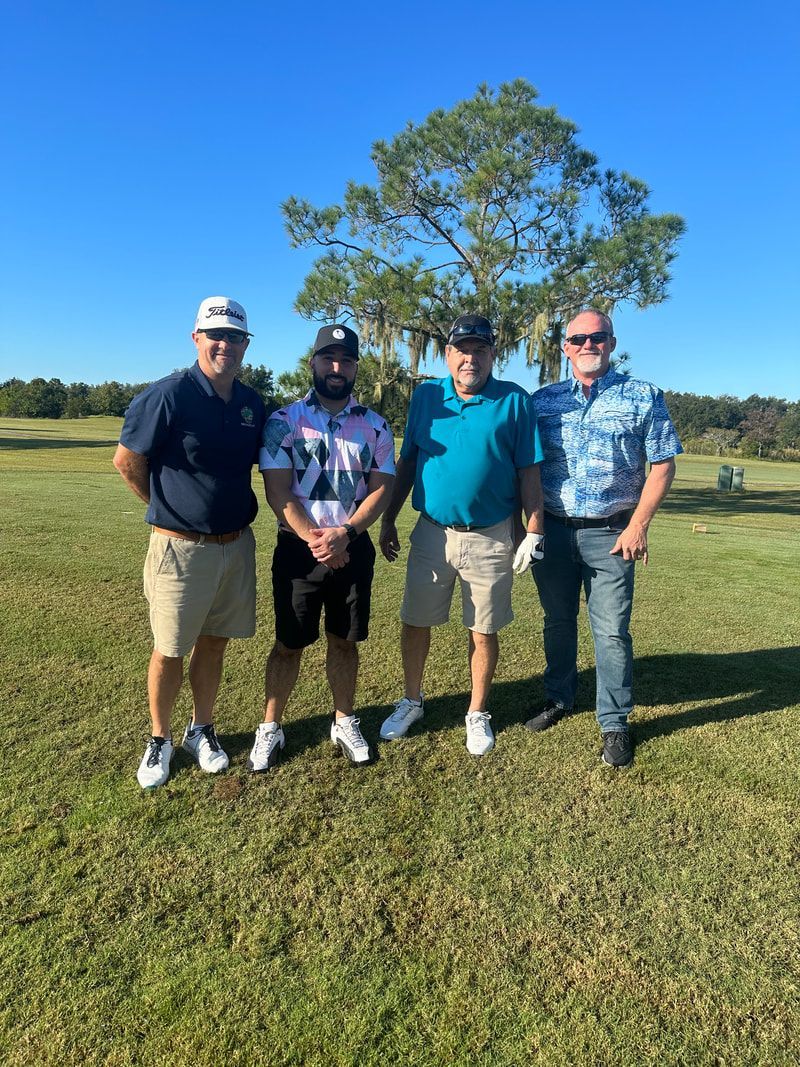 A group of men are posing for a picture on a golf course.