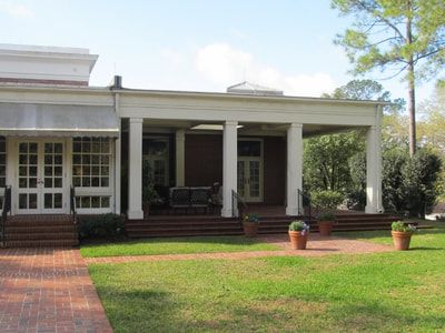 A large house with a porch and a brick walkway
