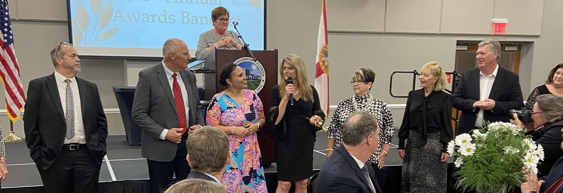 A group of people are standing around a podium in a room.