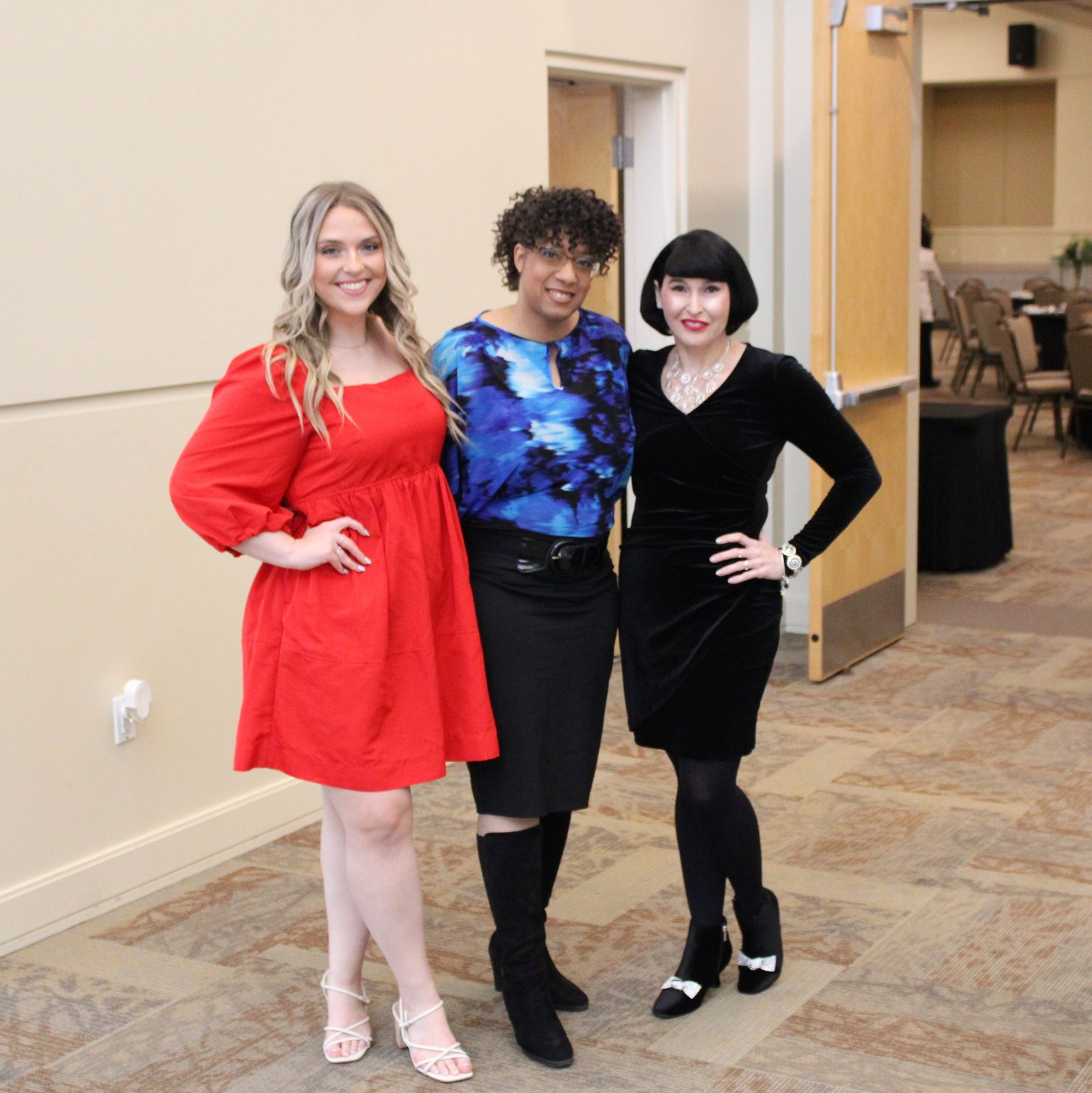 Three women standing next to each other in a room