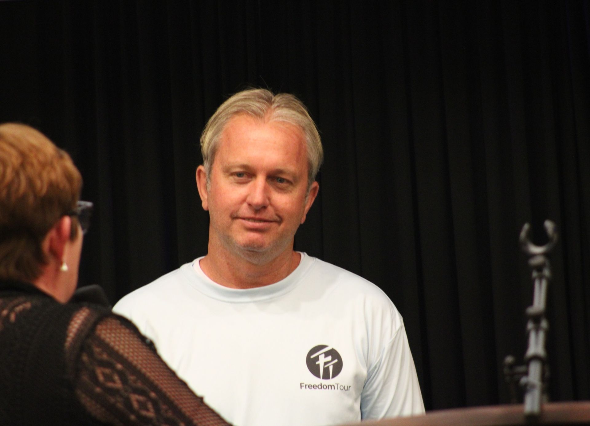 A man wearing a white shirt with the word freedom on it