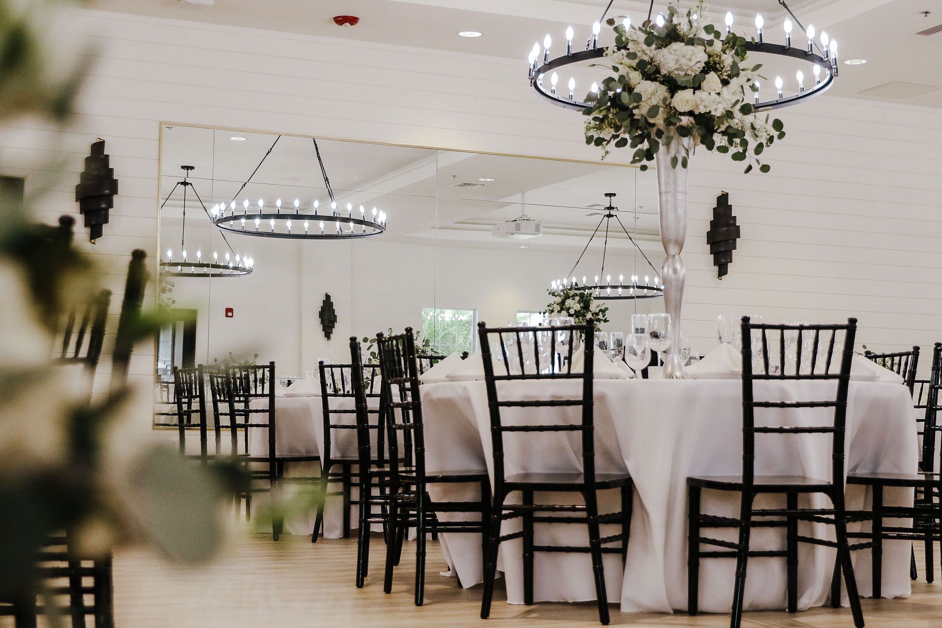 A large room with tables and chairs set up for a wedding reception.