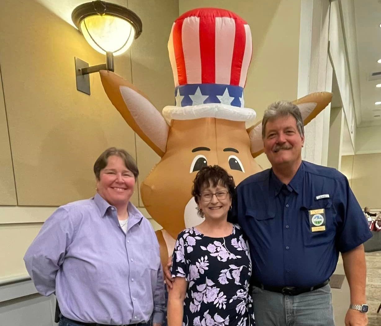 A group of people standing in front of an inflatable bunny wearing an uncle sam hat
