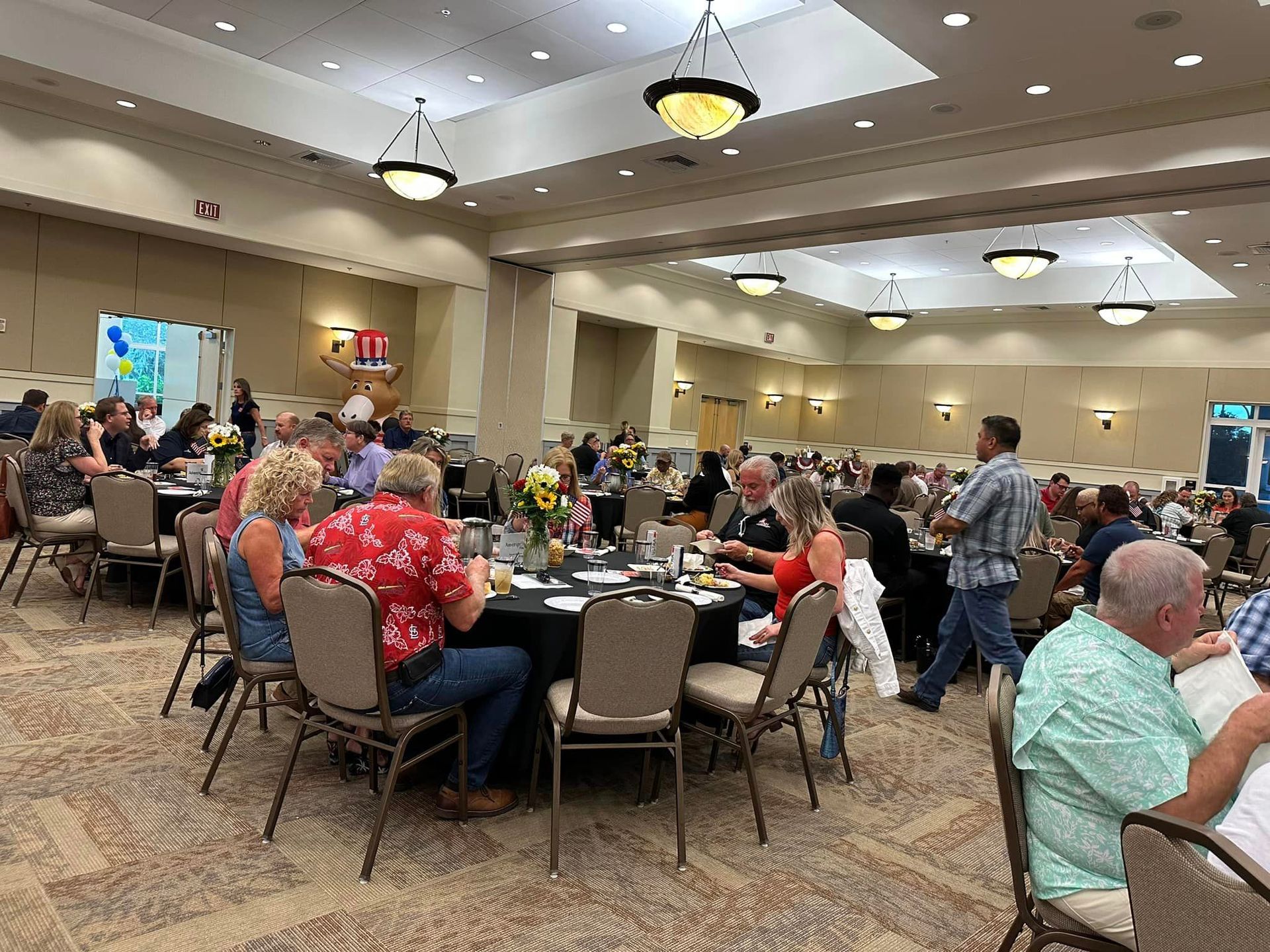 A large group of people are sitting at tables in a large room.