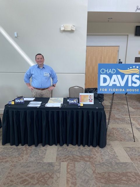 A man stands in front of a chad davis sign
