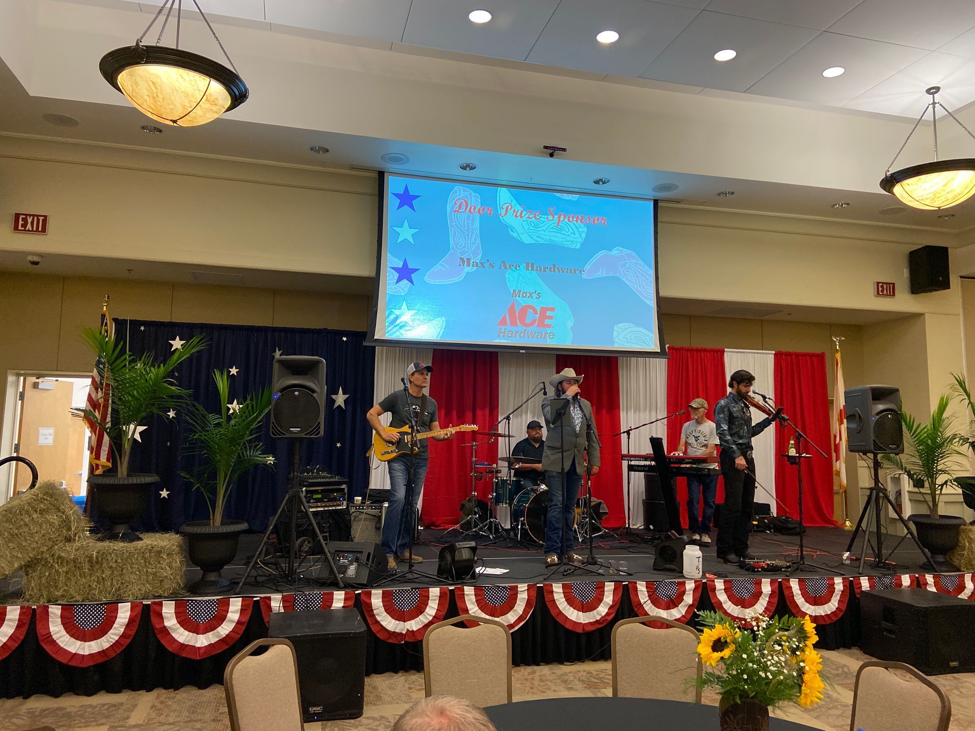 A group of people are standing on a stage in front of a large screen.