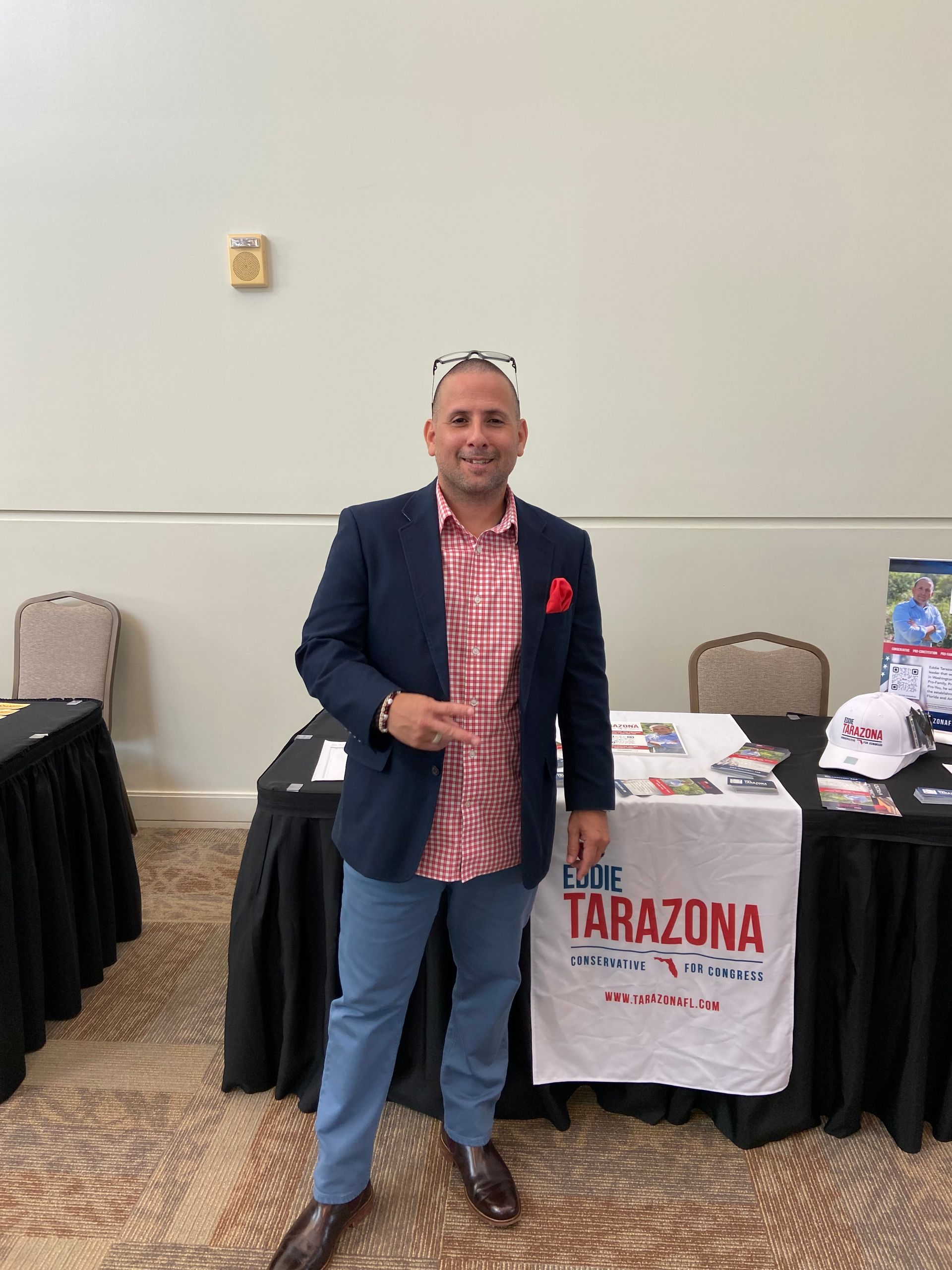 A man is standing in front of a table with a sign on it that says tarazona.