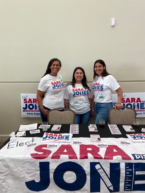 Three women standing in front of a table that says sara jone