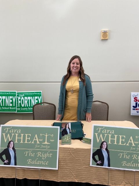A woman stands behind a table with tara wheat signs on it