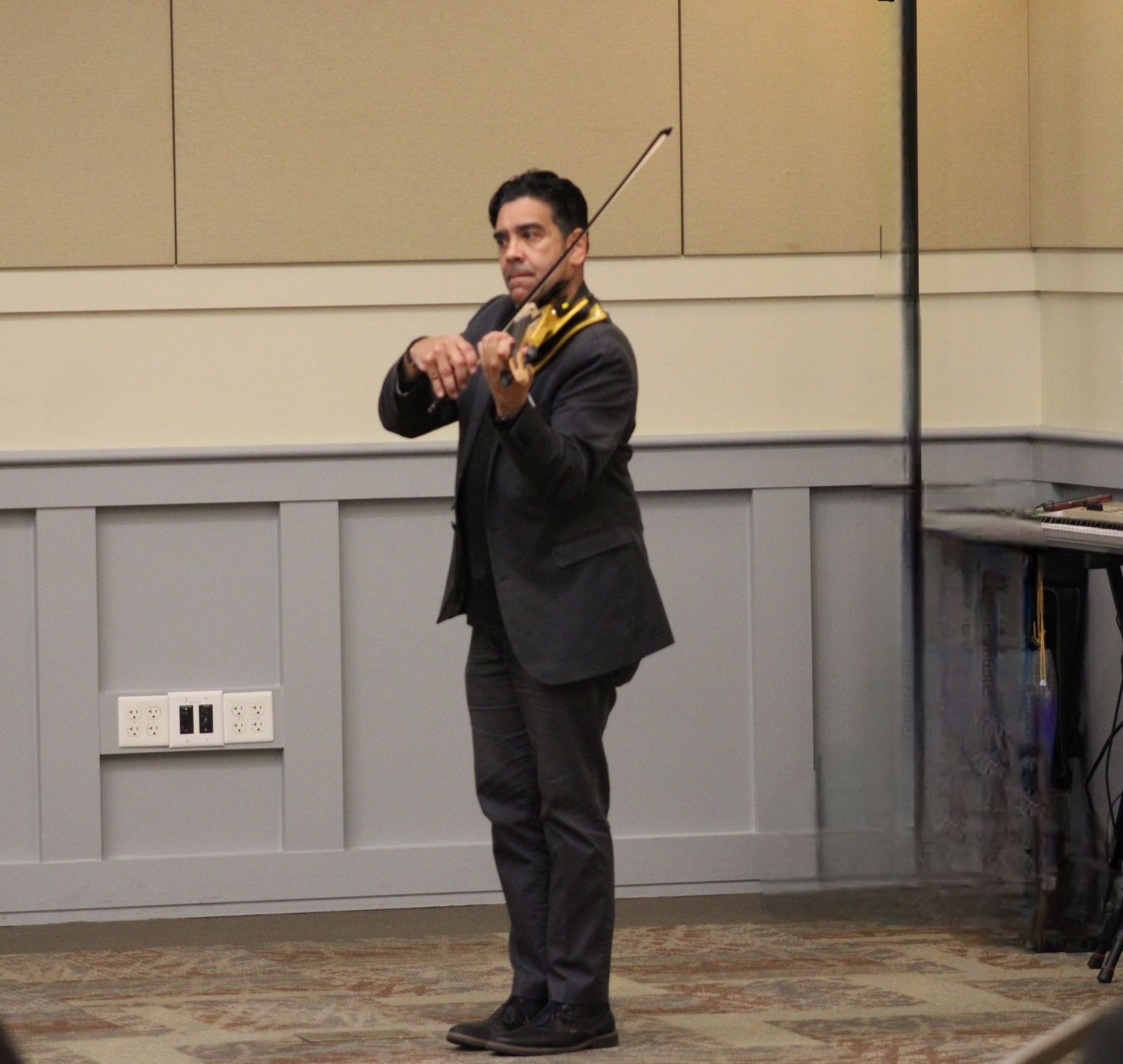 A man in a suit is playing a violin
