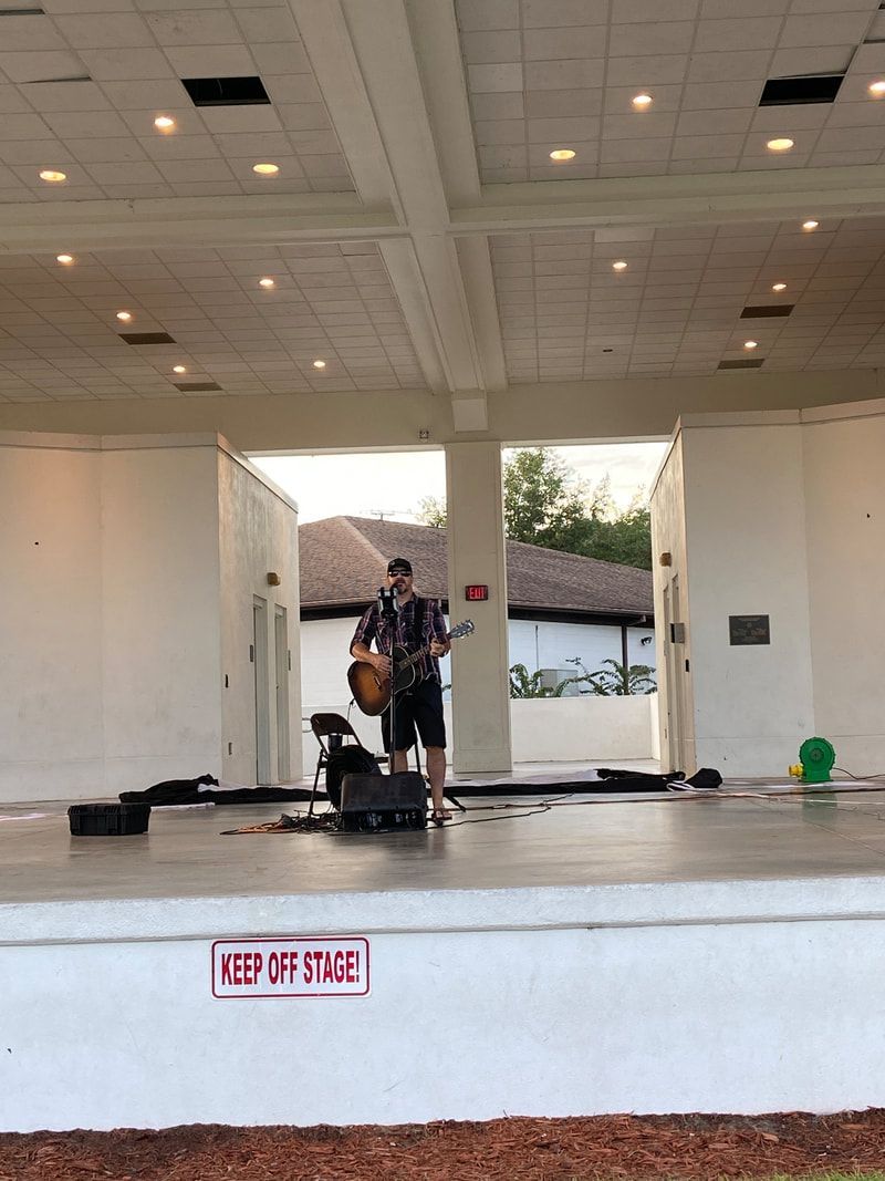 A man is standing on a stage playing a guitar.