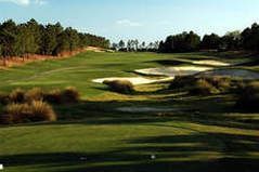 A golf course with a lot of grass and trees in the background.