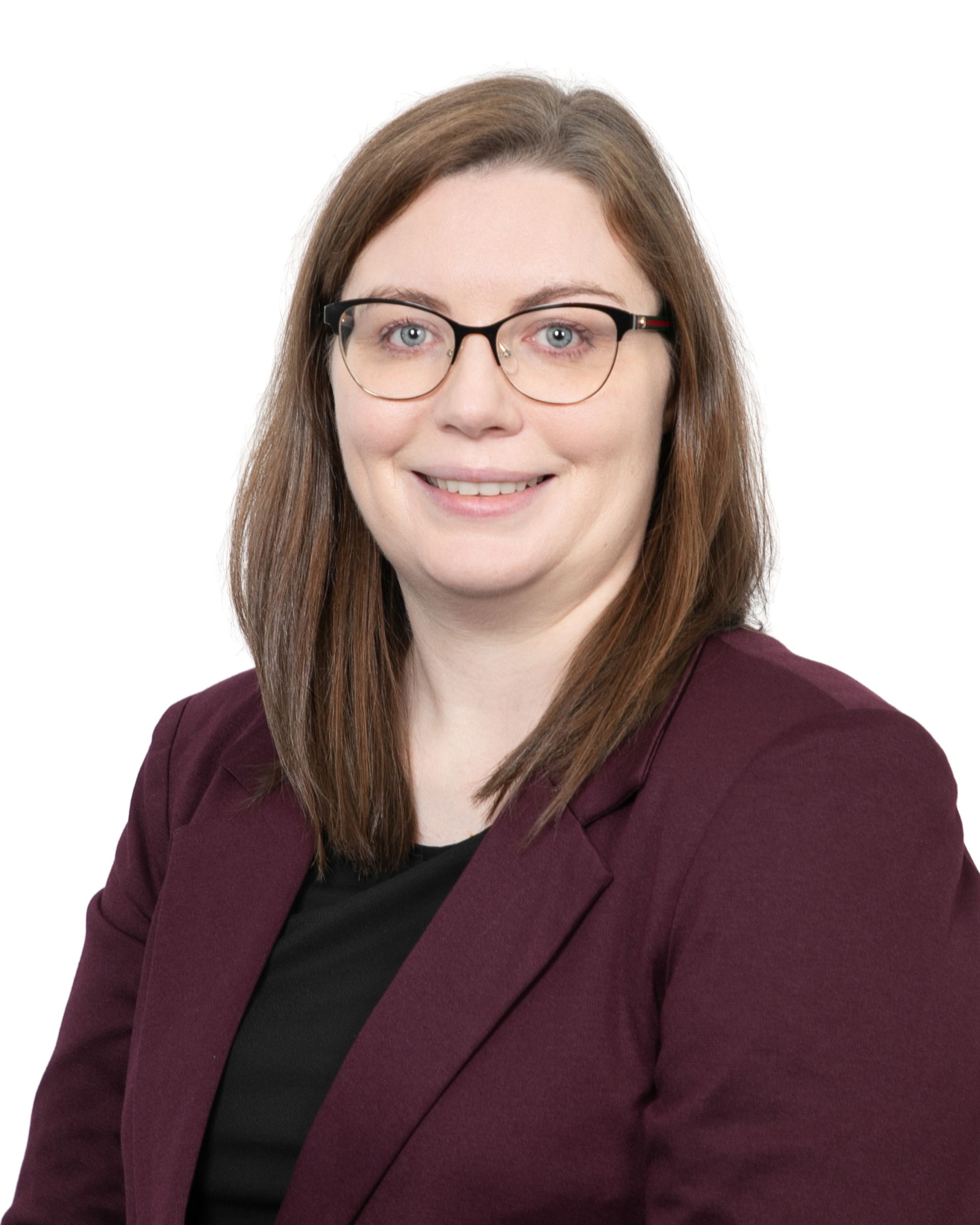 Portrait of a smiling person wearing glasses and a maroon blazer against a white background