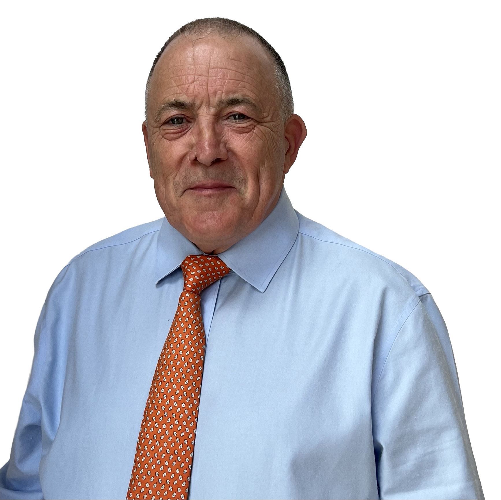 Man in a light blue shirt and orange tie, standing against a white background, looking at the camera.