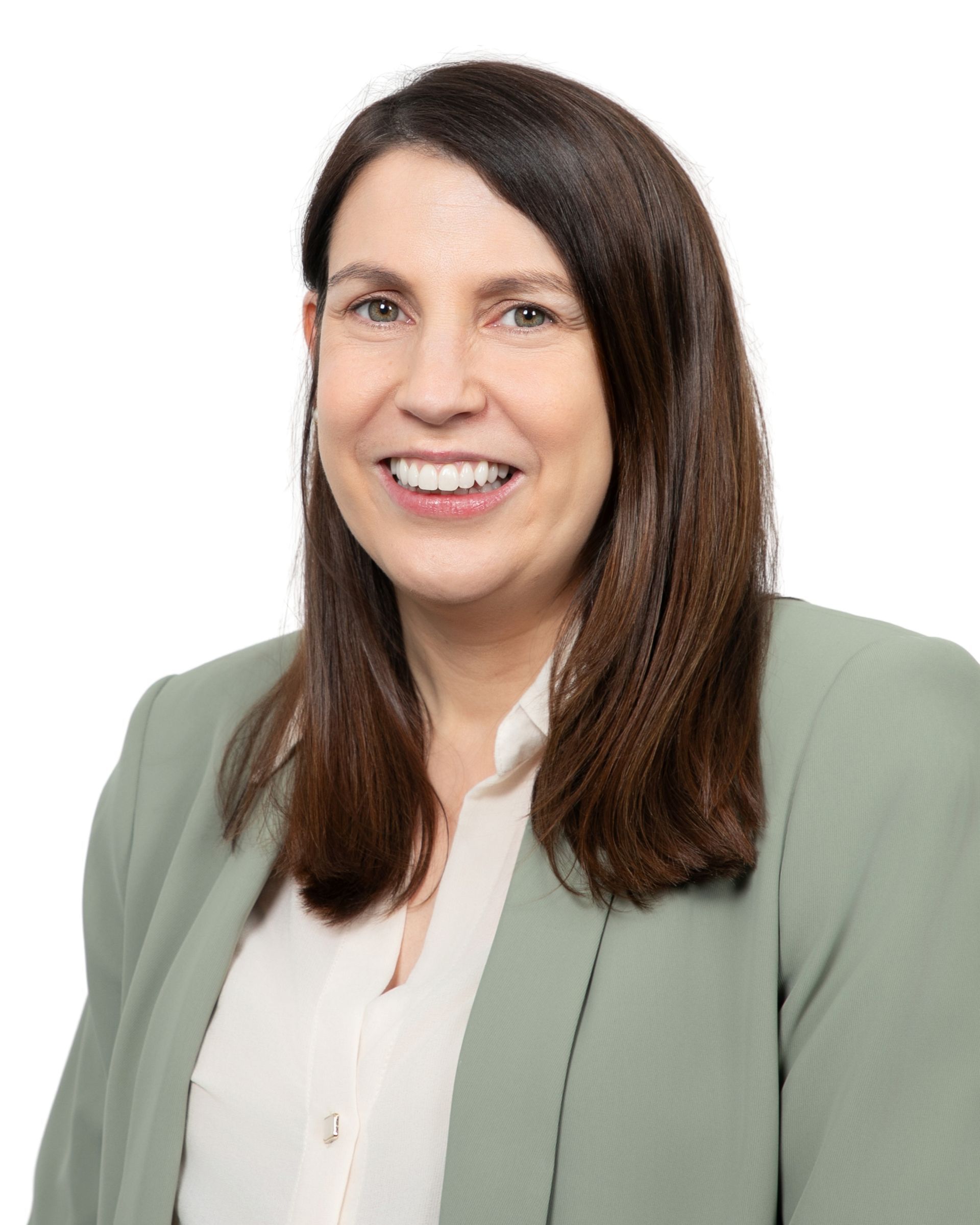 Smiling person in a light green blazer over a white blouse against a white background