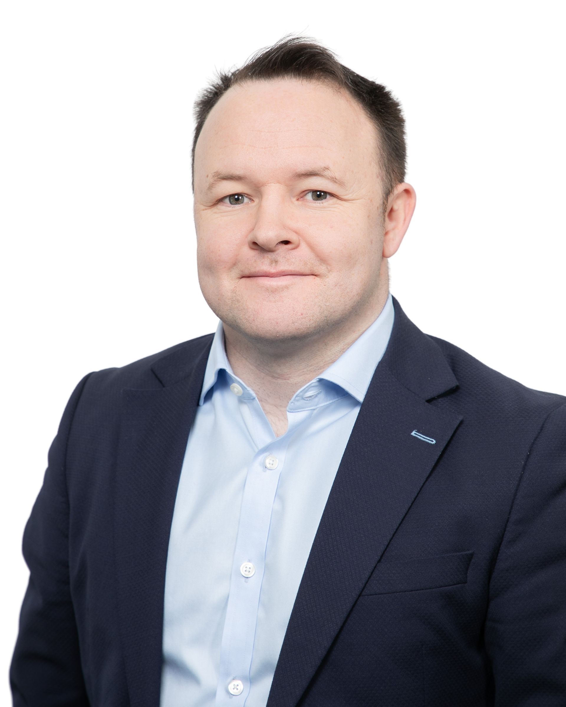 Portrait of a man in a navy blazer and light blue shirt against a white background