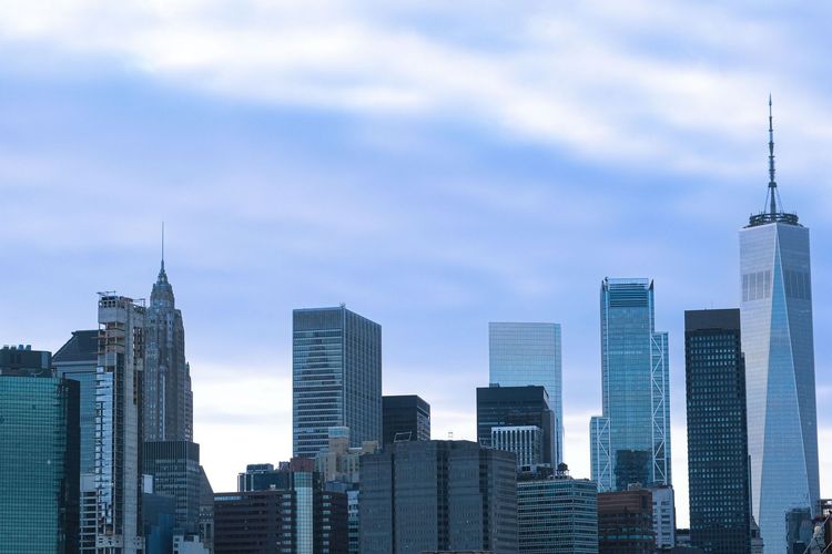 City skyline with modern skyscrapers under a blue cloudy sky