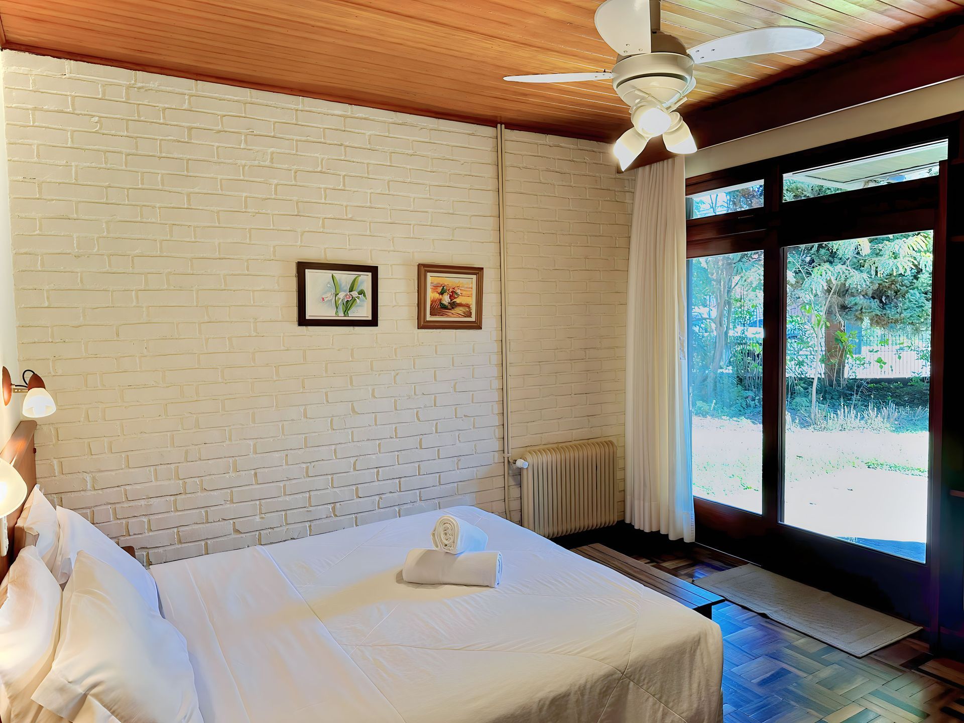 Um quarto com cama e ventilador de teto