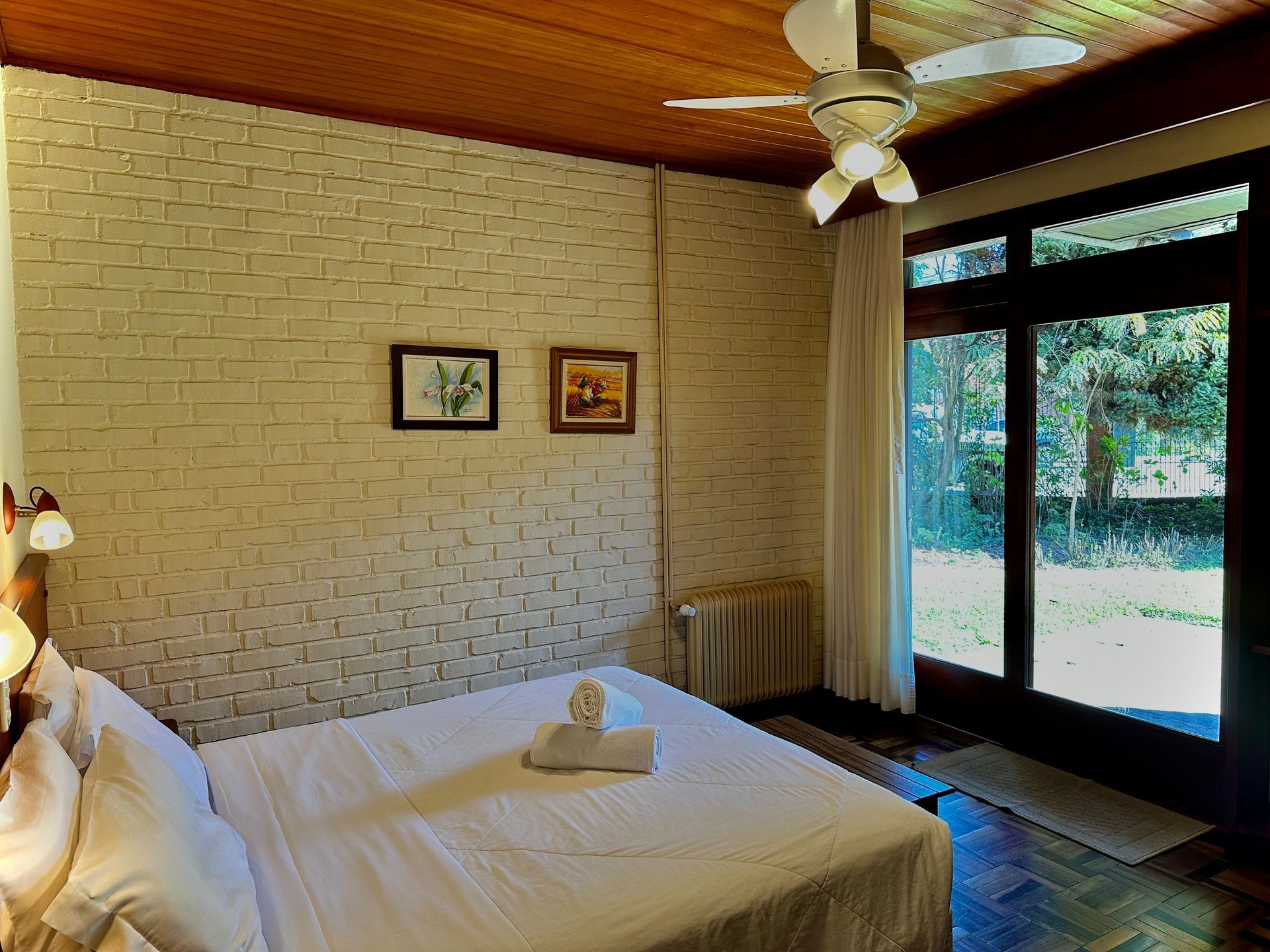 Um quarto com cama e ventilador de teto.