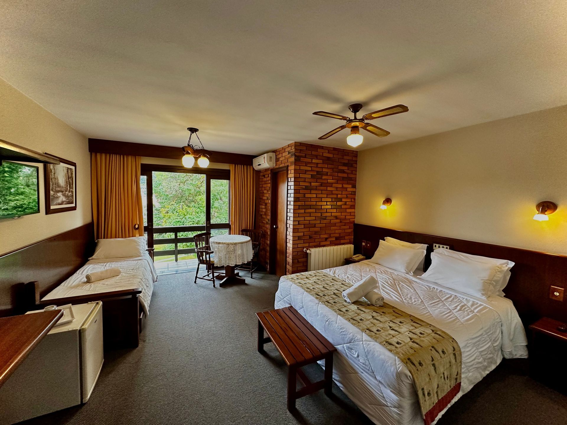 Um quarto de hotel com ventilador de teto e uma cama grande