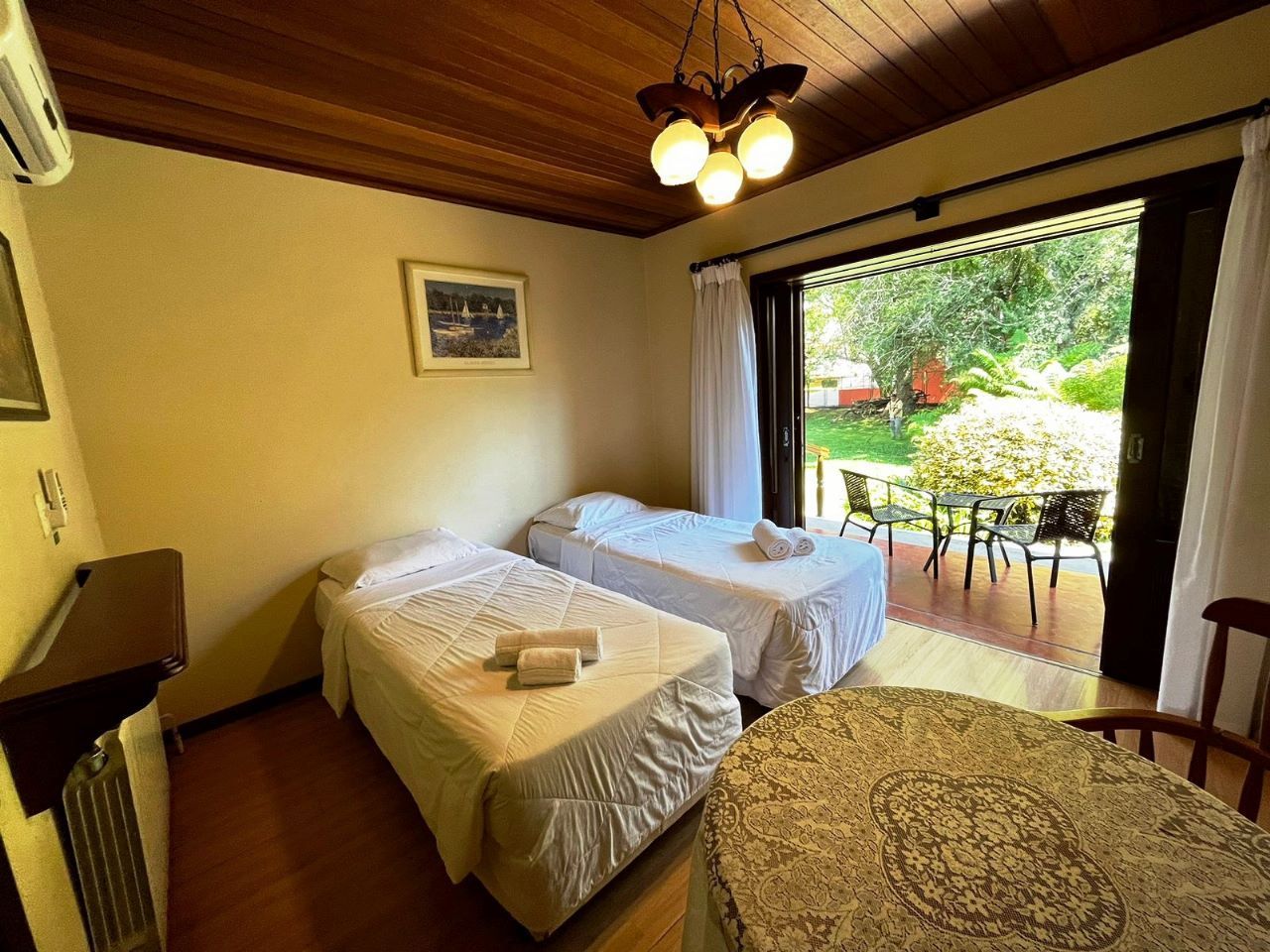 Um quarto com duas camas, mesa e cadeiras.