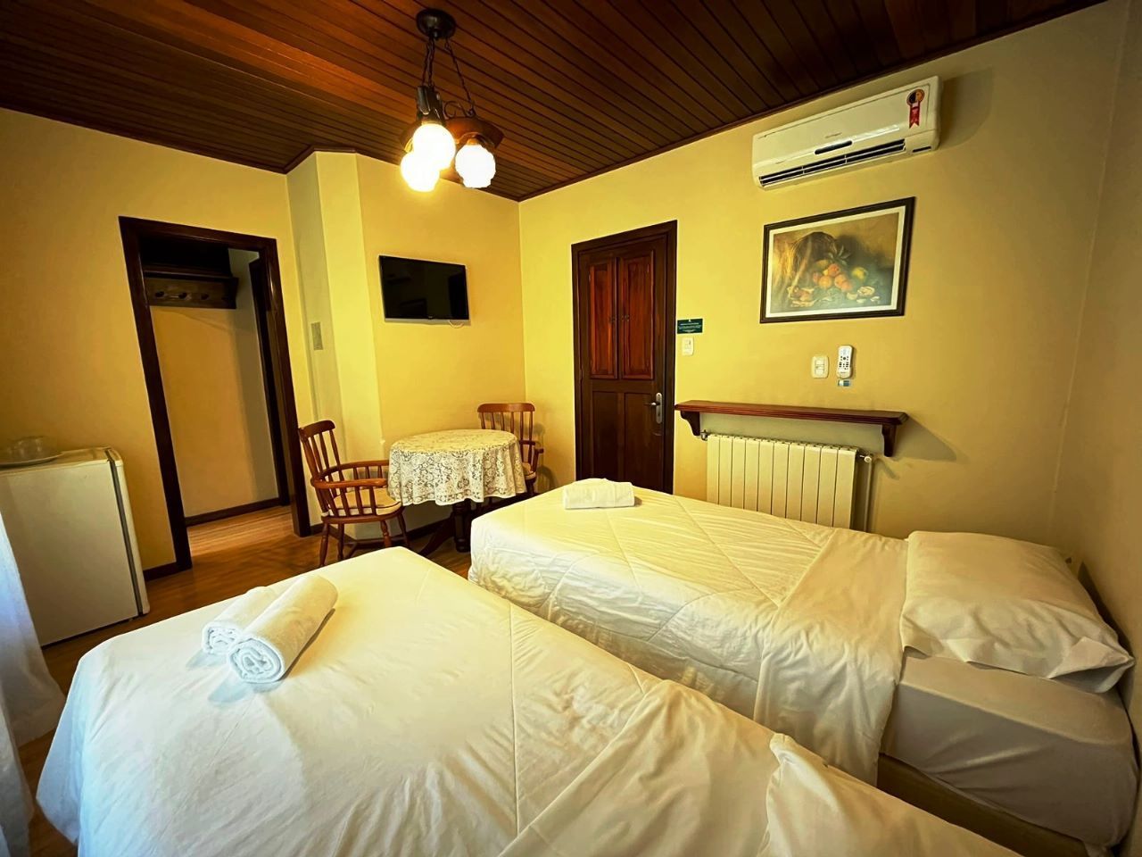 Um quarto de hotel com duas camas, mesa e cadeiras.