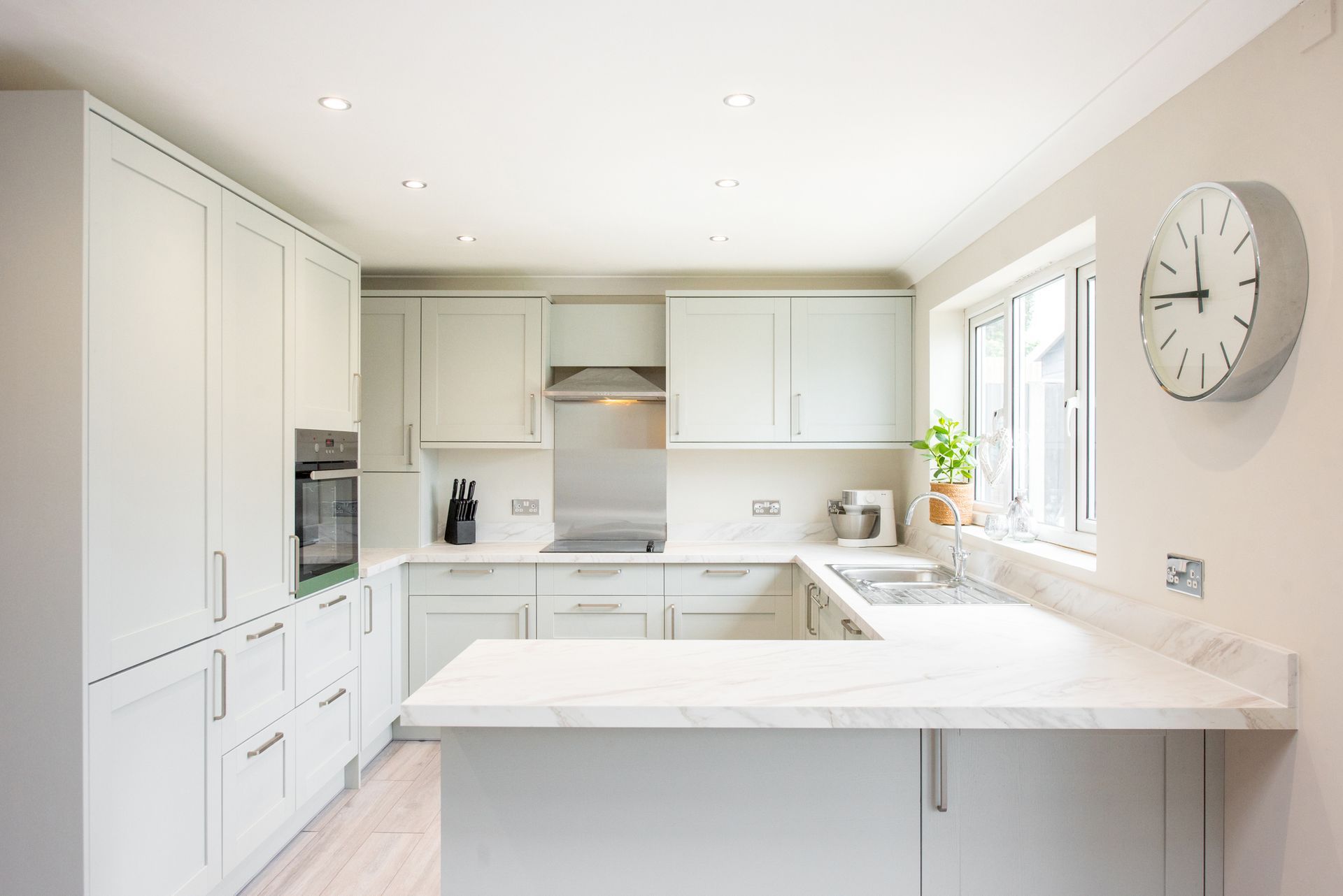 A Kitchen with White Cabinets and A Clock on The Wall — Greensboro, NC — Blackdog Handyman Service Inc.