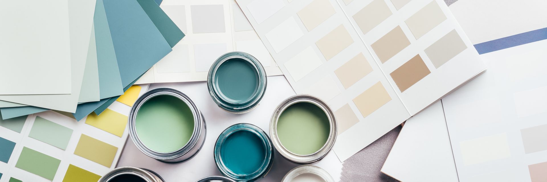 A Bunch of Paint Cans and Paint Samples on A Table — Greensboro, NC — Blackdog Handyman Service Inc.