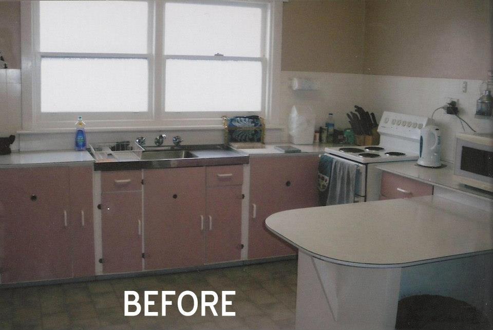 Before photo of a pink kitchen with sink, stove, and island countertop