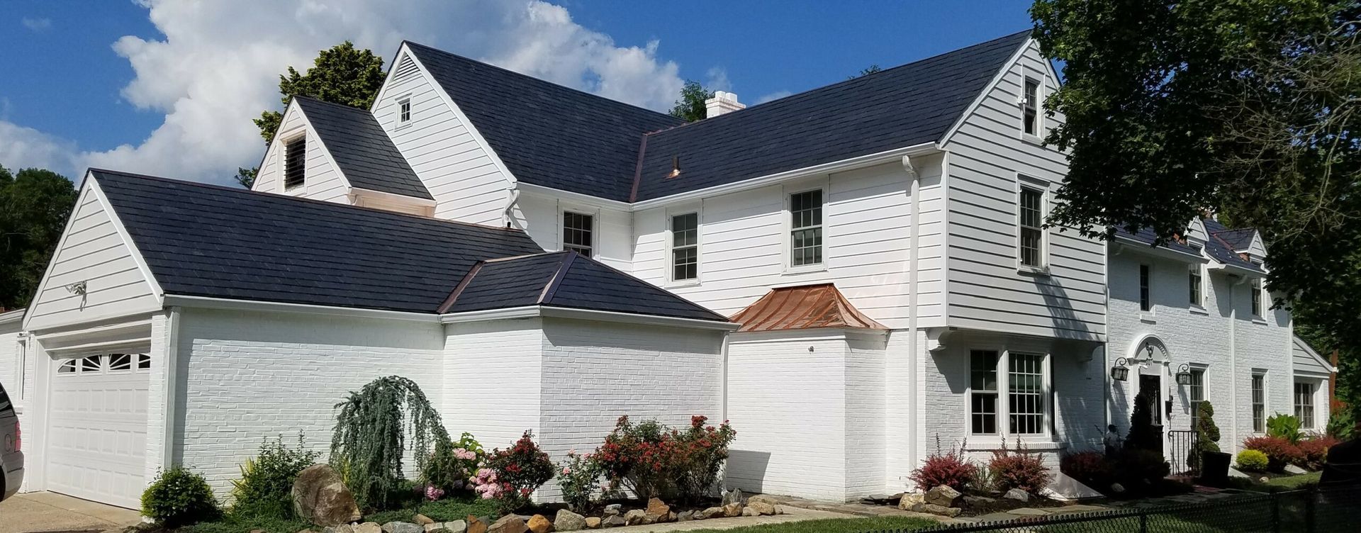 A large white house with a black roof.