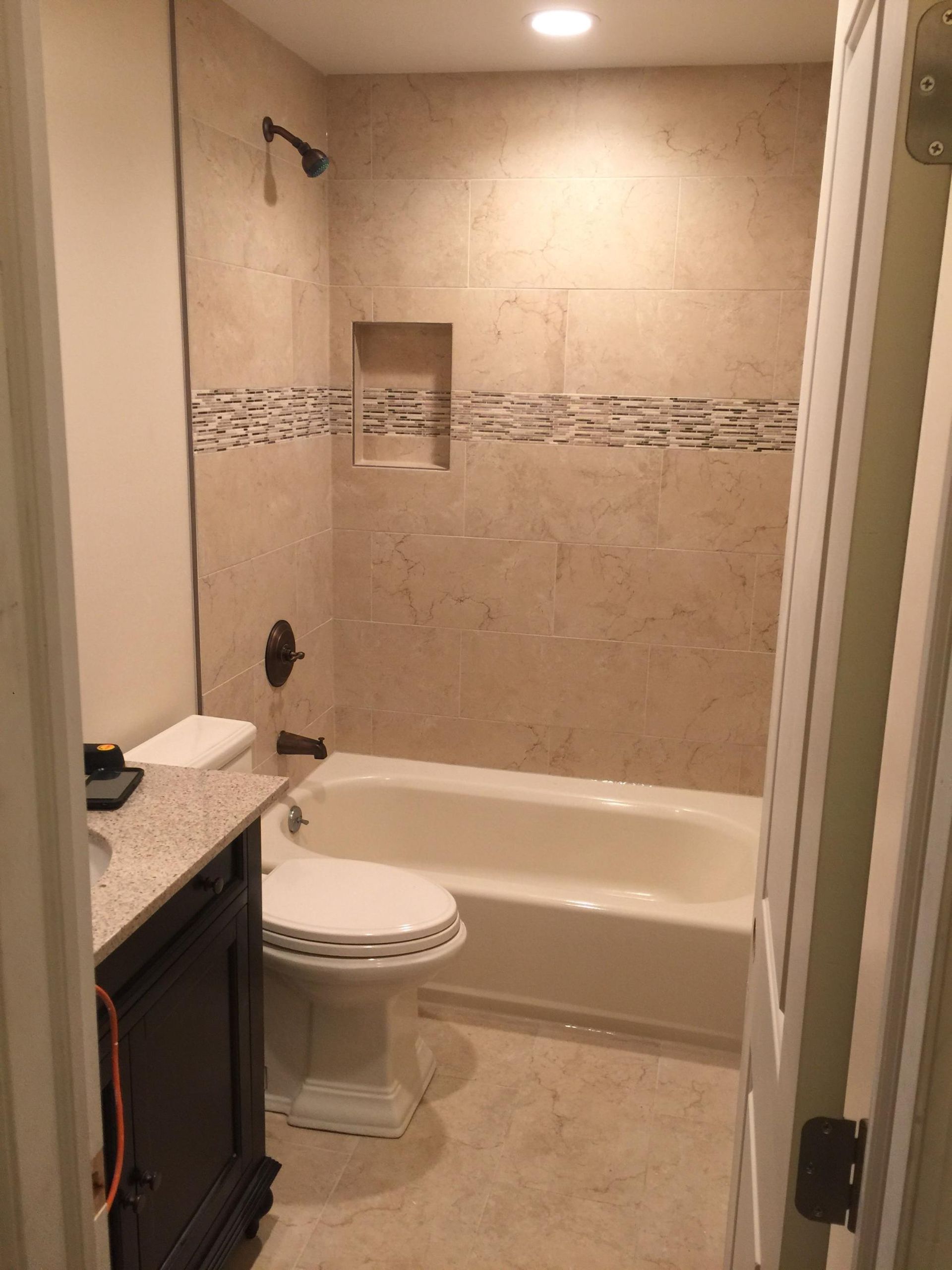 A bathroom with a toilet , tub and shower.