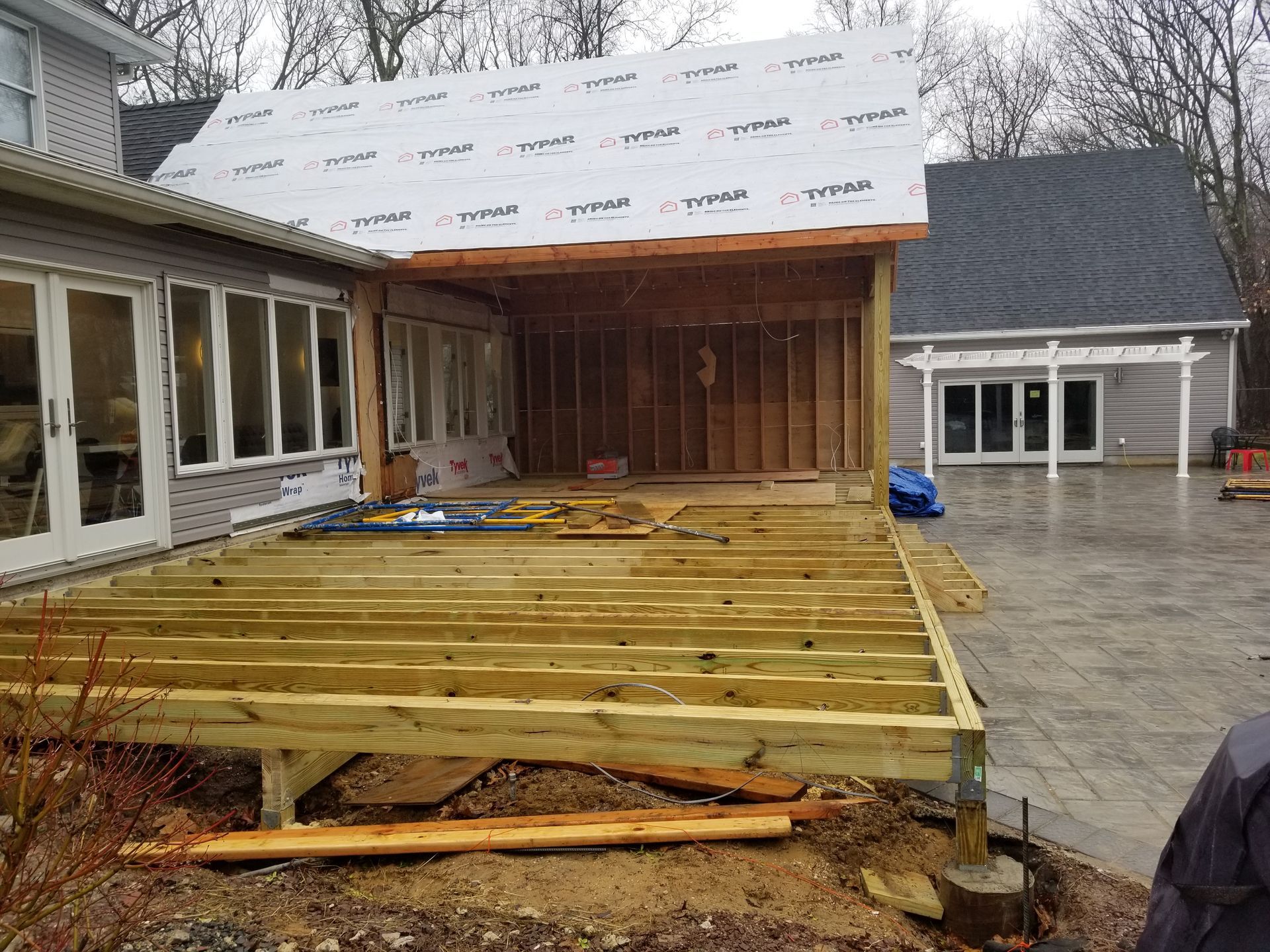 A wooden deck is being built in front of a house.