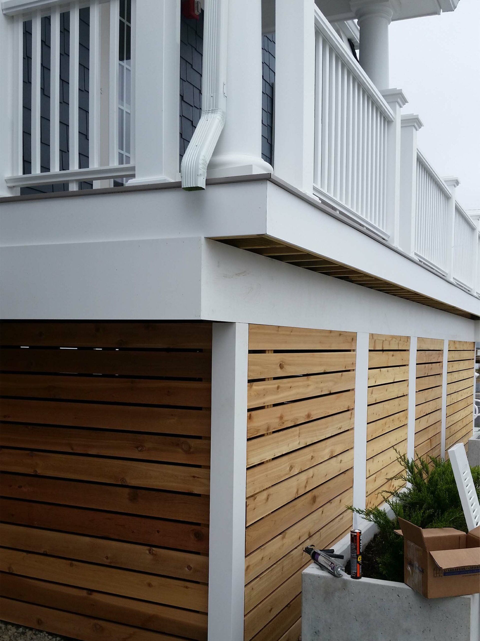 A house with a wooden fence and a white railing.