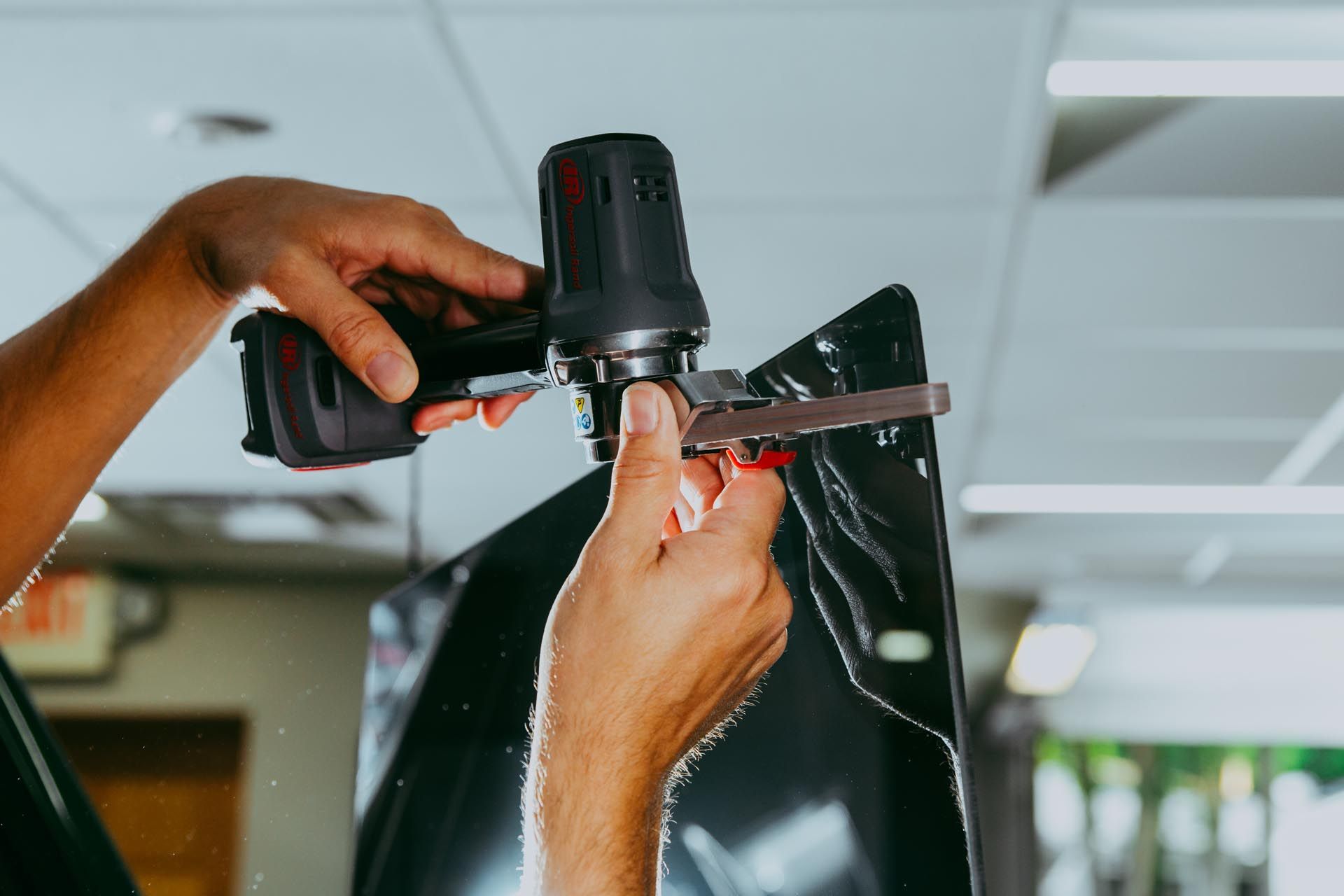 A person is using a drill on a piece of metal.