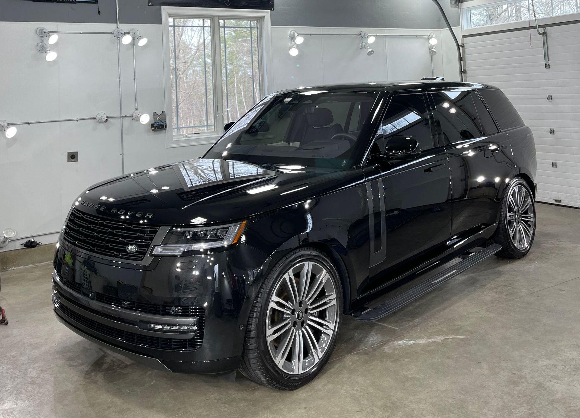 A black range rover is parked in a garage.