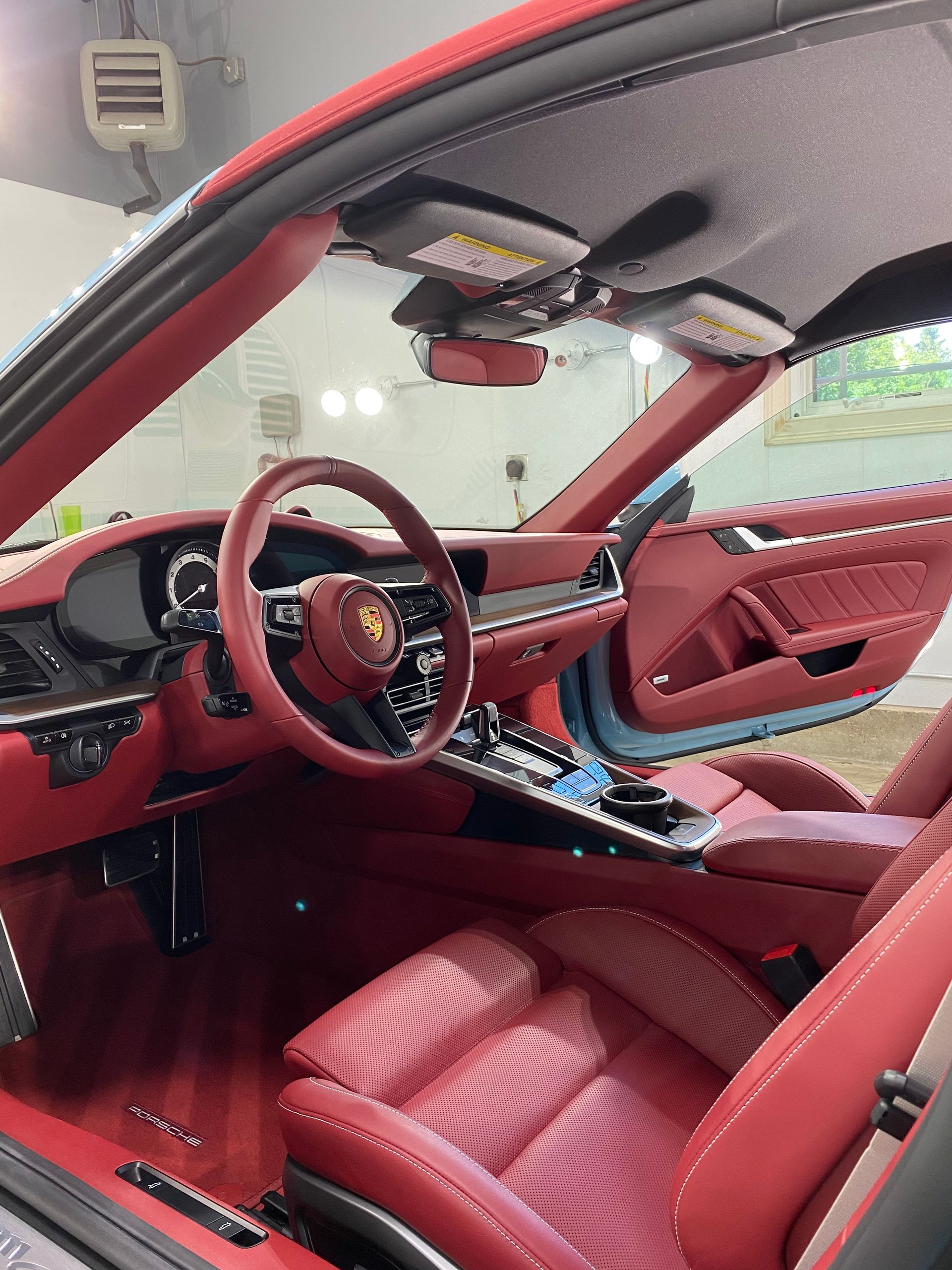 The interior of a red sports car with red seats and a steering wheel.