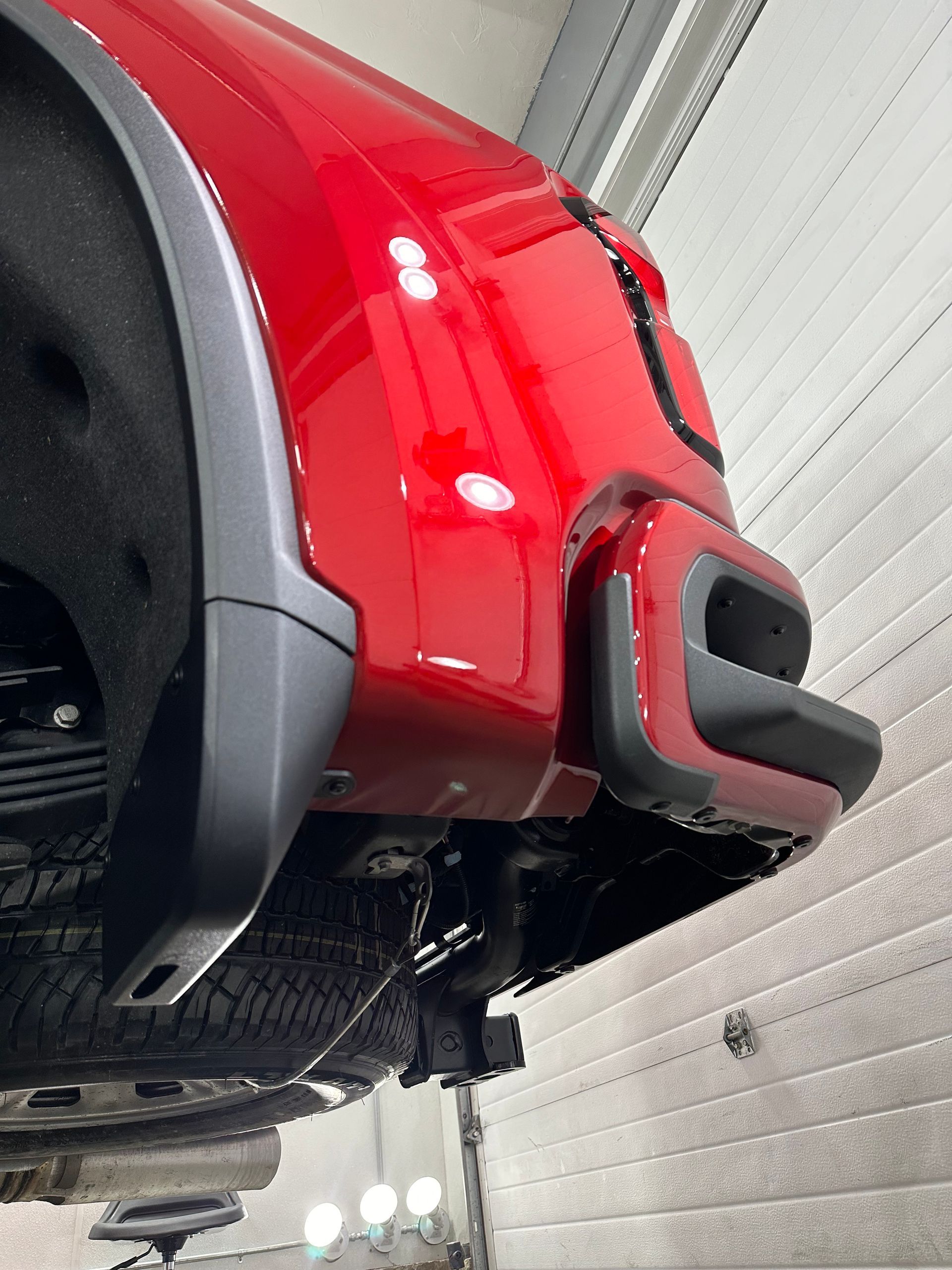 A red truck is parked in a garage.