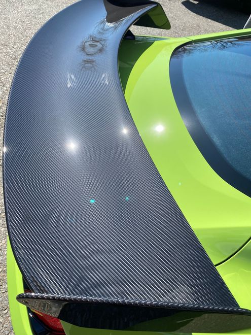 A close up of a green car with a black spoiler