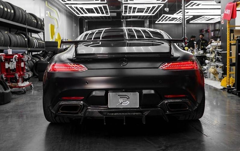 A black sports car is parked in a garage.