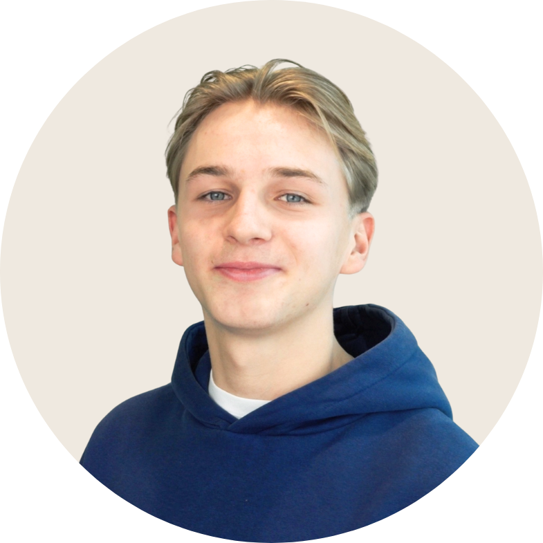 Een jongeman in een blauwe hoodie lacht naar de camera.