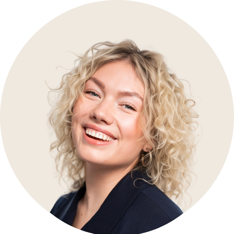 Een vrouw met krullend blond haar staat lachend in een kring.