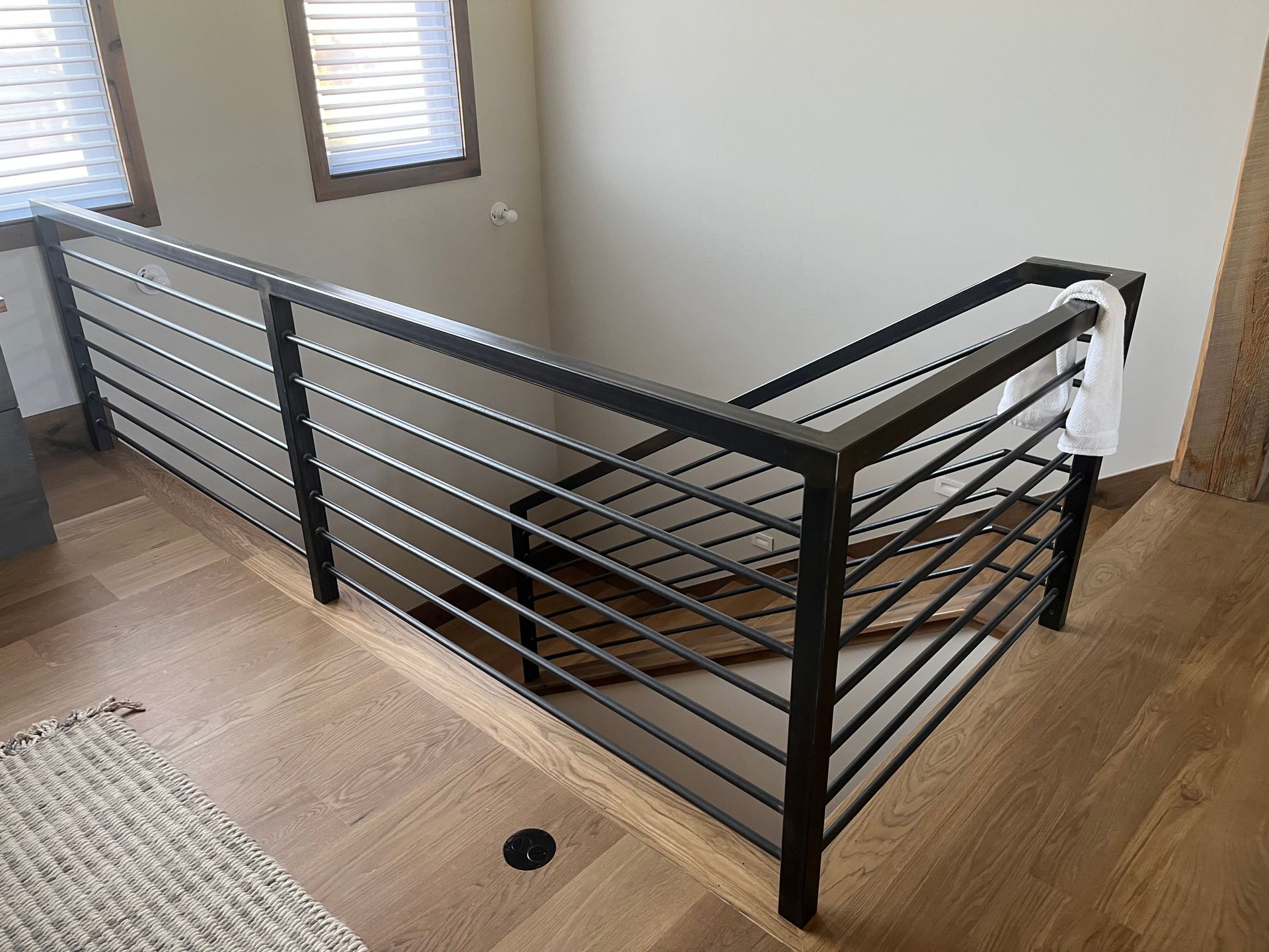 A staircase with a metal railing and wooden floors in a house.
