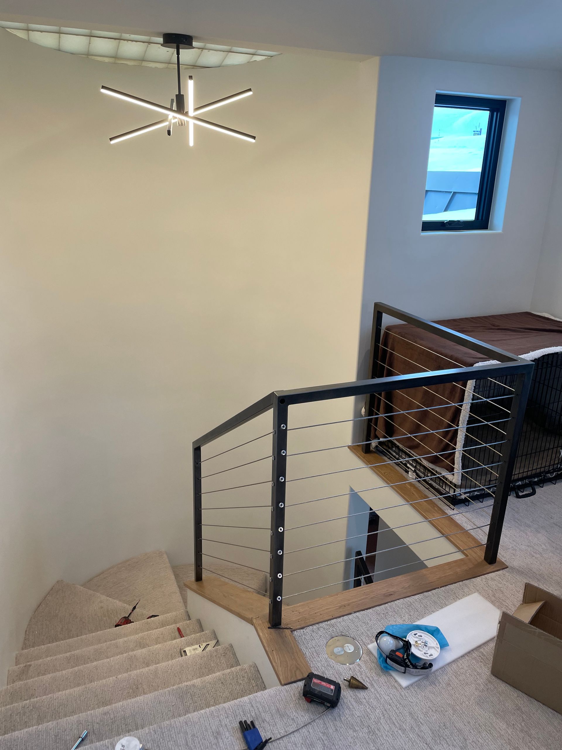 A staircase with a railing and a chandelier hanging from the ceiling.
