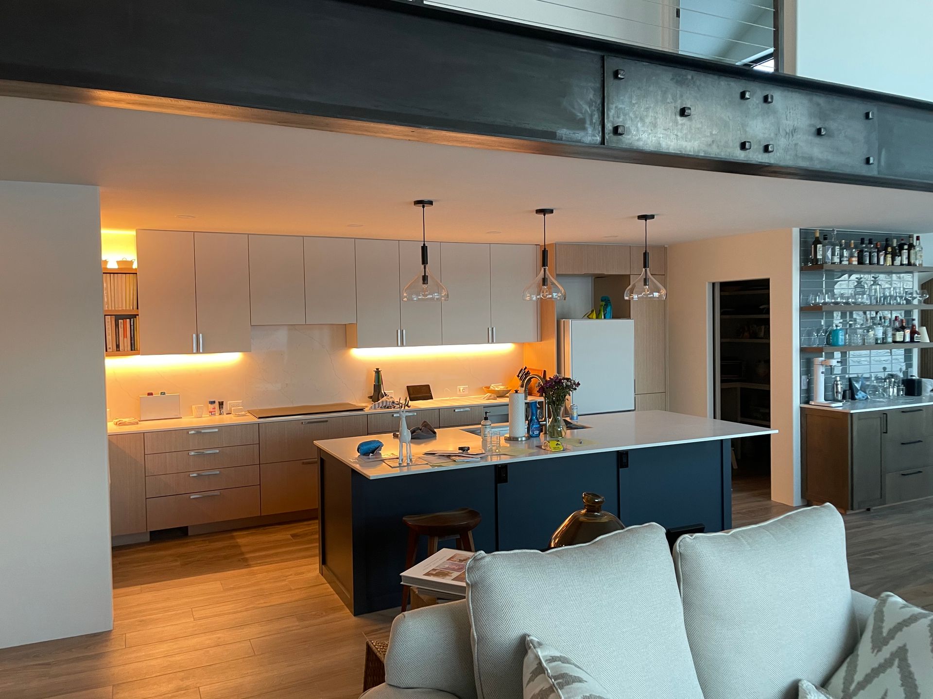 A living room with a couch and a kitchen in the background.